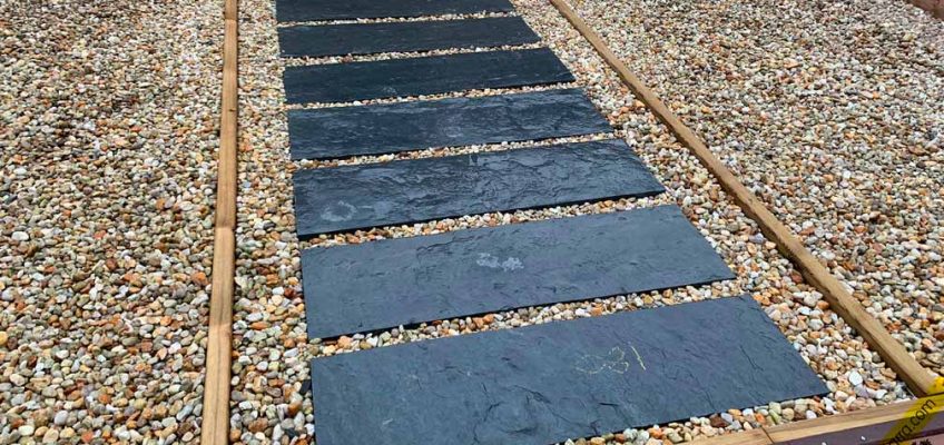 Camino de piedra en entrada de vivienda.