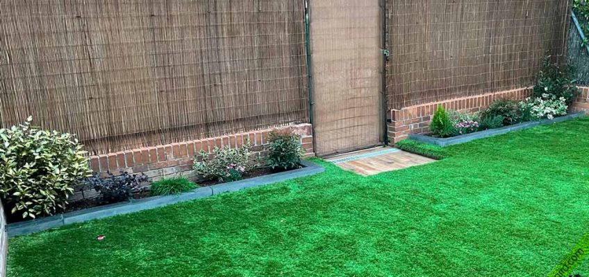 Bordillo de pizarra natural delimitando césped y tierra