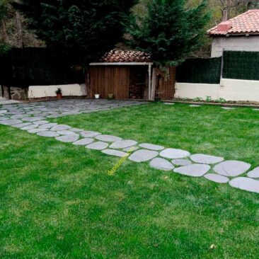 Camino de pizarra sobre césped en jardín