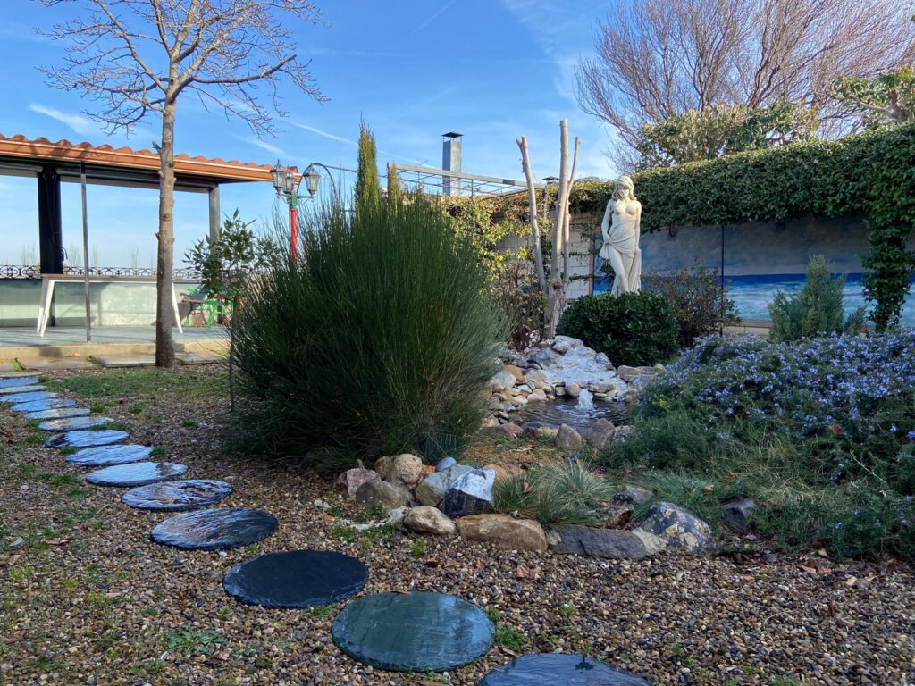 Jardín de bajo consumo de agua con grava y piedra natural.