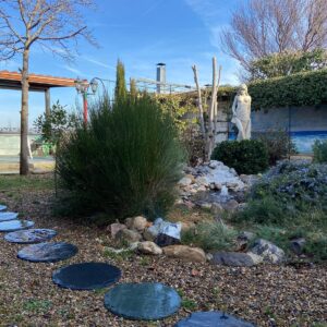Jardín de bajo consumo de agua con grava y piedra natural.
