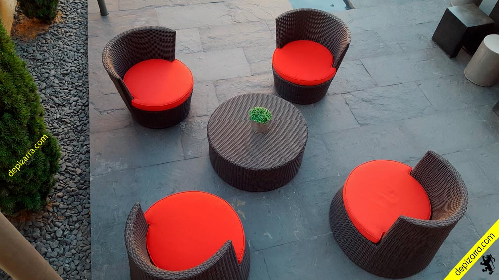 Suelo de pizarra natural en patio exterior con sillones
